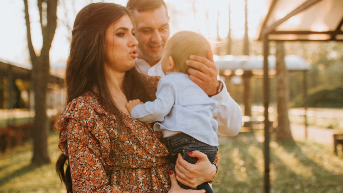 a man and woman holding a baby in their arms
